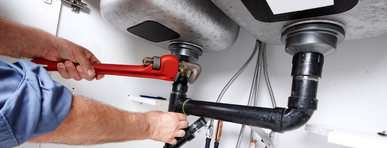 Hands of Plumber with a wrench.